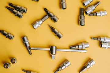 Collection of various tools arranged on a yellow surface for a DIY project or repair work