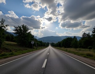 Winding Road Through Scenic Landscape Under Bright Sunlight and Fluffy Clouds