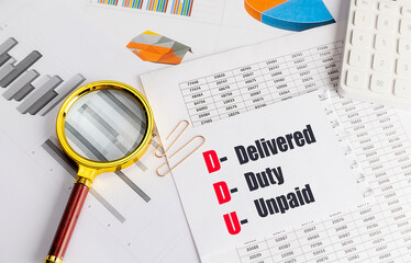 Acronym DDU delivered duty unpaid written on paper with magnifying glass, charts, and calculator