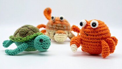 Two crocheted sea animals&mdash;a green-blue turtle and orange crab&mdash;crafted with yarn on white background.