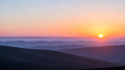 Obraz premium Sunrise over misty mountain peaks in hues of orange and purple