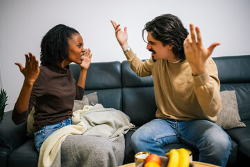 oung couple in disagreement on sofa
