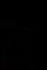 Obraz premium Sparse band of pale dust specks stretching across deep black void, tiny particles glimmering like a distant galaxy, forming a minimalist abstract night sky filled with subtle cosmic texture