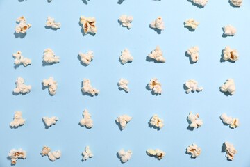 Fototapeta premium Tasty popcorn on light blue background, flat lay