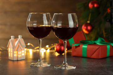 Glasses of red wine and Christmas decor on grey table