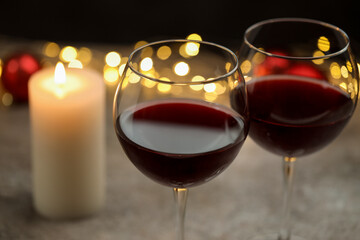 Glasses of red wine and Christmas decor on gray table, closeup