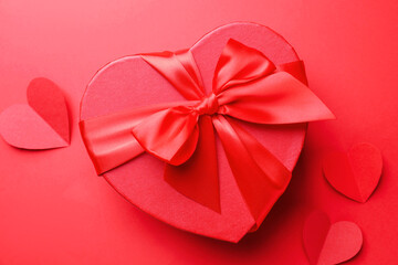 Happy Valentine's Day. Heart shaped gift box and paper hearts on red background, flat lay