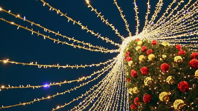 Illuminated christmas tree with cascading string lights at night