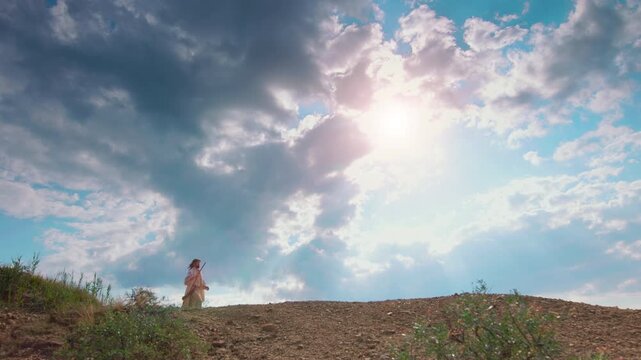 A robed Wanderer crossing a rugged, sunlit desert terrain with natural clay hills and soft contours. Atmospheric wilderness scenery suggesting pilgrimage, reflection, and spiritual journey.