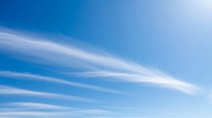 Wispy cirrus clouds streaking across a bright blue sky