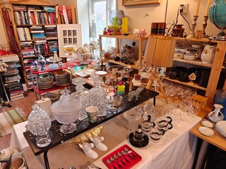 Vintage and everyday household items displayed in a thrift store, second-hand shop interior with retro objects and used goods for resale