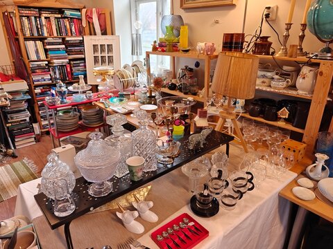 Vintage and everyday household items displayed in a thrift store, second-hand shop interior with retro objects and used goods for resale