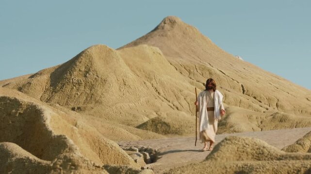 Traveler dressed in simple biblical-style robes exploring an austere and sculptural desert environment. The earthy tones of the natural formations evoke a sense of timeless wandering.