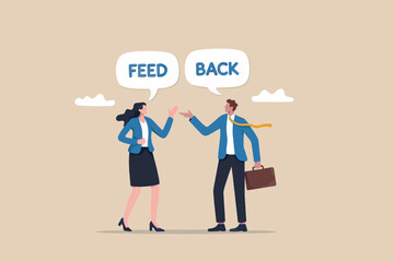 Two business colleagues exchange feedback during a meeting or discussion