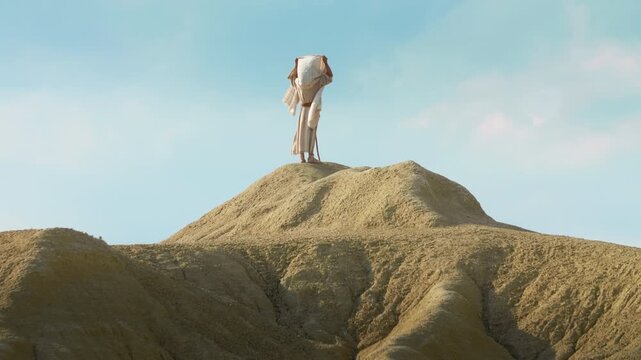 A solitary Traveler on a desert praying on a hilltop. Christian and spiritual concept