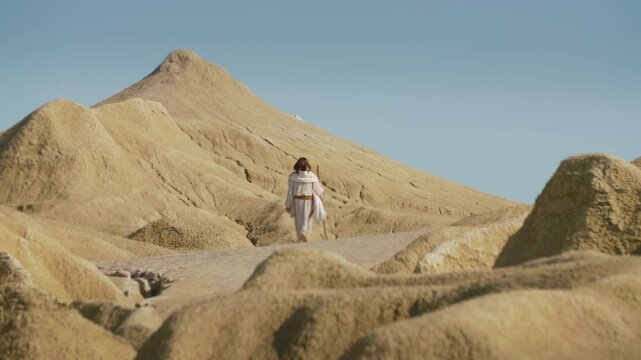 A Traveler�s feet step forward on a dry, rocky path. Christian and spiritual concept