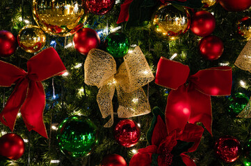 A beautifully decorated Christmas tree at night, adorned with glowing lights, bows, and ornaments, creating a festive and elegant holiday atmosphere.
