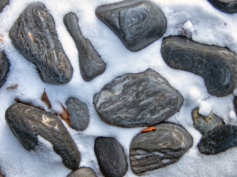 Snow on small black rocks