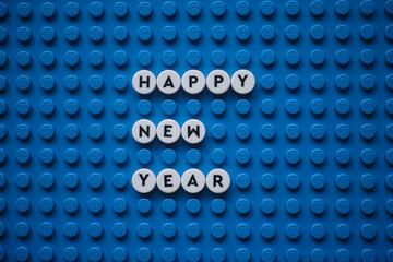 Obraz premium Tambov, Russian Federation - December 06, 2025 The phrase Happy New Year on a blue Lego baseplate. The scene is made out of Lego dots.