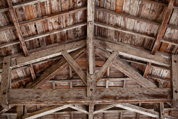 Weathered planks and beams under the roof of a barn