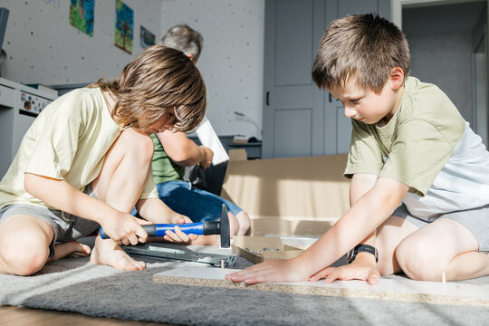 Children building furniture with father, learning diy skills