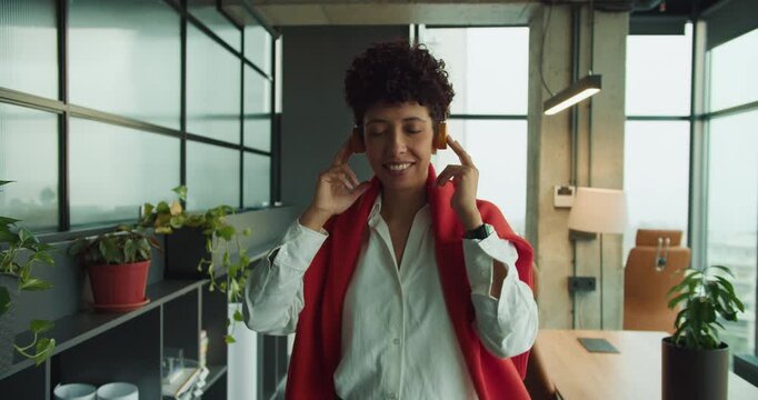 black marketing exec enjoys headphones in green office