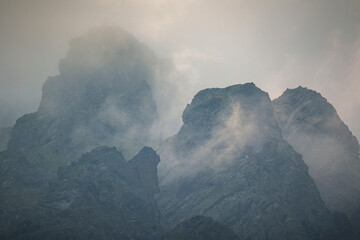 Jagged mountain peaks shrouded in mist and dramatic light