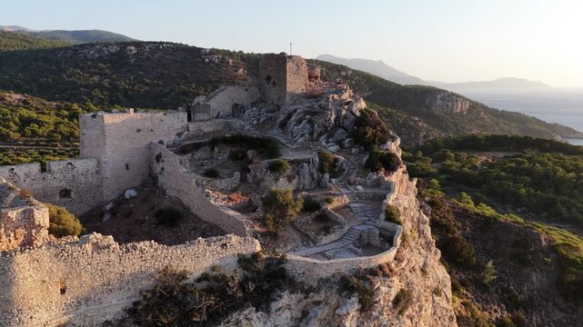 Aerial view of Monolithos Castle ruins perched on a cliff in Rodos Greece at sunset