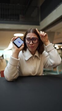 Vertical screen girl frowns at her phone accusing the artificial intelligence of giving wrong advice showing frustration and disbelief in a tense emotional moment of their conversation