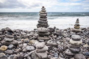 Stone figures on a beach with a beautiful sky in Tenerife. Canarian Island. Balance and serenity. High quality photo.