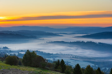 Autumn mountain view and peaceful landscape with fog and sunlight at dawn, Beskid, Poland, natural background or nature photo wallpaper
