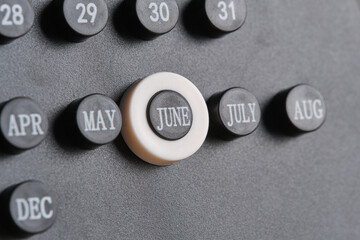 Month June on stylish black calendar, close up.