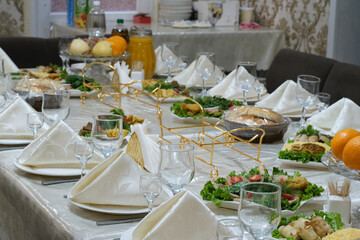 Wedding banquet table with cutlery, glasses and food.