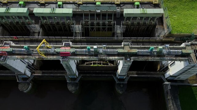 Wide drone view of Tail Sluice hydraulic barrier on the River Nene near Kings Lynn UK showing tidal gates, water flow control and extensive hydro engineering