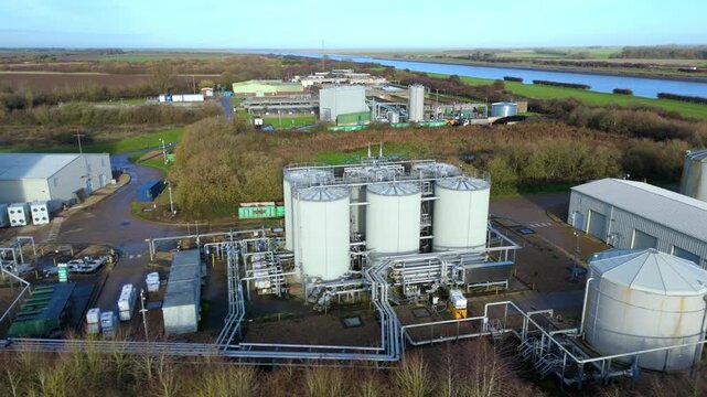 Wide drone shot of extensive Anglian Water biosolids site featuring sewage removal systems, treatment basins, storage tanks and environmental operations near Kings Lynn UK