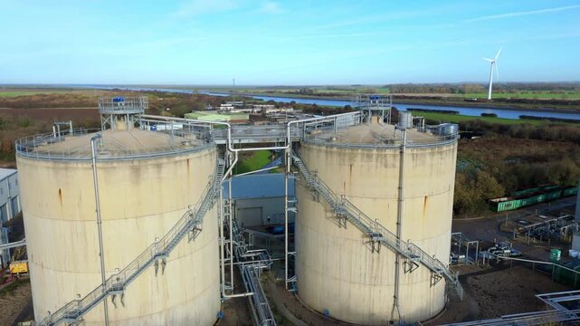 Aerial drone view of Anglian Water biosolids treatment facility with sewage processing tanks, sanitation systems, and settling ponds near Kings Lynn in rural UK landscape
