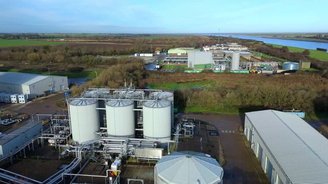 Aerial drone view of Anglian Water biosolids treatment facility with sewage processing tanks, sanitation systems, and settling ponds near Kings Lynn in rural UK landscape