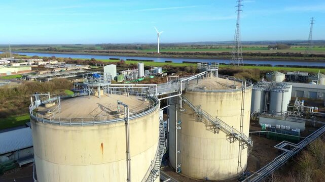 Aerial drone view of Anglian Water biosolids treatment facility with sewage processing tanks, sanitation systems, and settling ponds near Kings Lynn in rural UK landscape