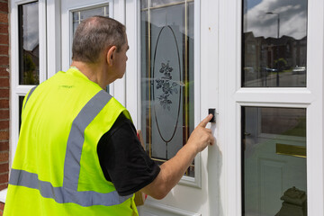 Courier in high viz pressing doorbell for delivery of online shopping parcel