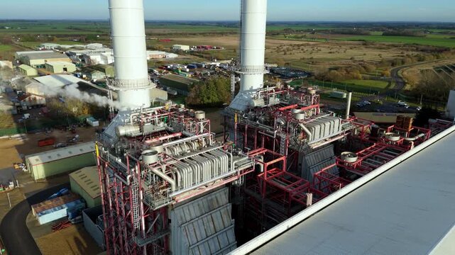 Close up Aerial drone view of Industrial power plant infrastructure, mechanical piping and vents of chimney stack and powerhouse, Sutton Bridge, UK.