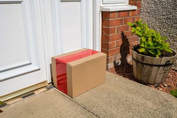 Delivered Cardboard Online Shopping Parcel Left on Doorstep of Suburban Home