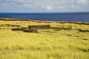 Rugged stone ruins on plains with ocean backdrop on Easter Island