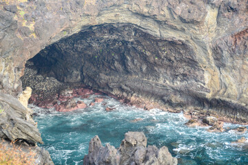 Sea cave with turquoise waters on rugged Easter Island coastline
