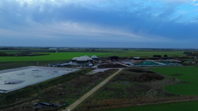 Aerial drone view of rural biogas energy plant, power station using renewable agricultural waste in countryside, domes and electricity generation near Wisbech, UK