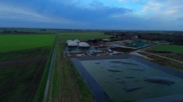 Aerial drone view of rural biogas energy plant, power station using renewable agricultural waste in countryside, domes and electricity generation near Wisbech, UK