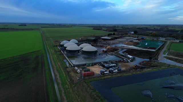 Aerial drone view of rural biogas energy plant, power station using renewable agricultural waste in countryside, domes and electricity generation near Wisbech, UK