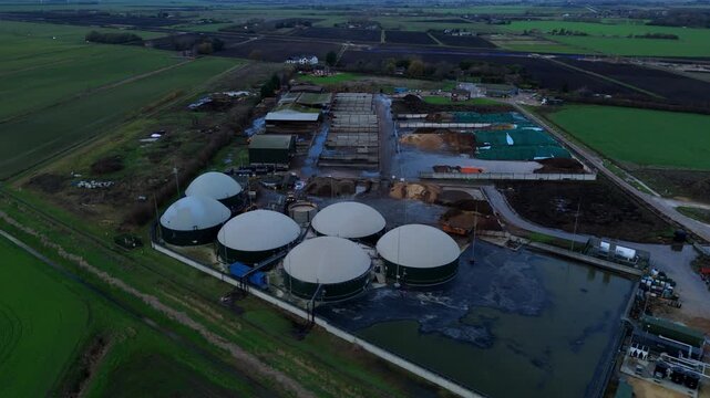 Aerial drone view of rural biogas energy plant, power station using renewable agricultural waste in countryside, domes and electricity generation near Wisbech, UK