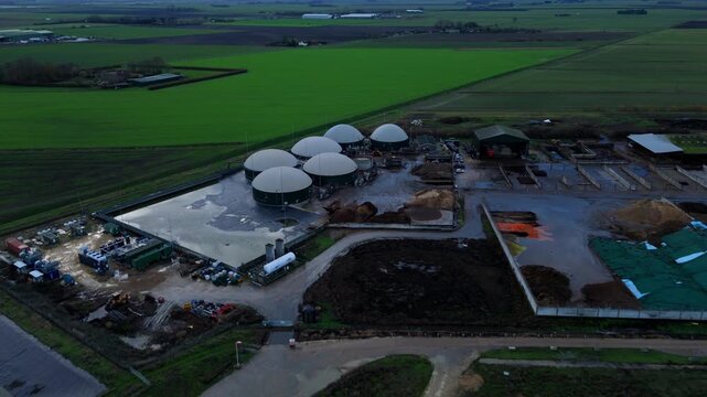 Aerial drone view of rural biogas energy plant, power station using renewable agricultural waste in countryside, domes and electricity generation near Wisbech, UK