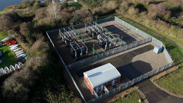 Aerial drone perspective of a small electrical sub station with transformers for grid power and energy relay near the River Nene, Kings Lynn, UK