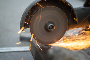 angle grinder in operation. A man saws metal, sending sparks. High quality photo